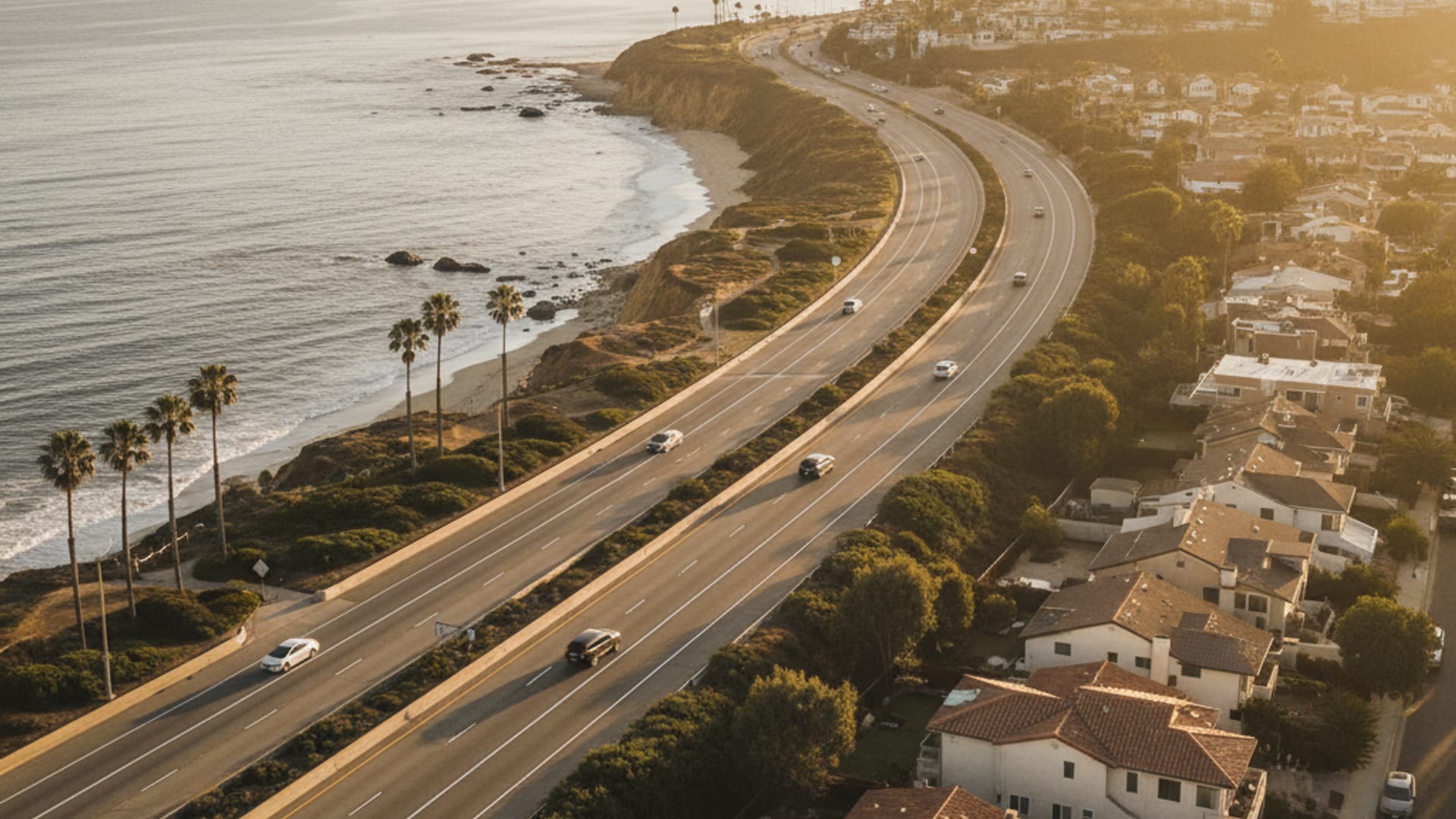 Aerial view of Orange County freeway network at golden hour showing coastal Huntington Beach through inland Irvine to canyon Silverado